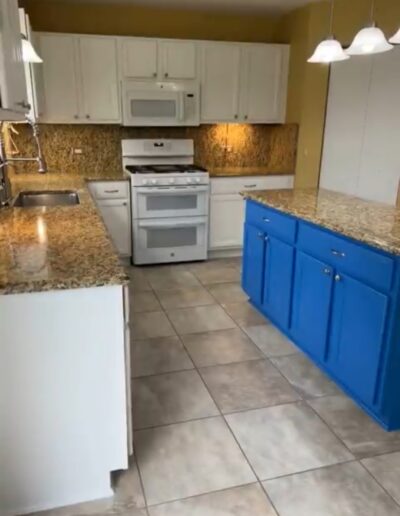 A kitchen with blue cabinets and granite counter tops.