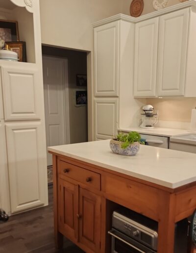 A kitchen with white cabinets and a center island.