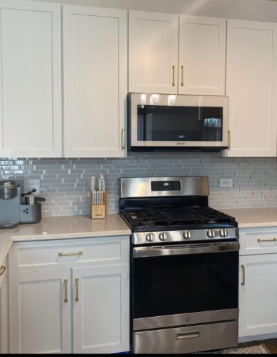 A kitchen with white cabinets and stainless steel appliances.