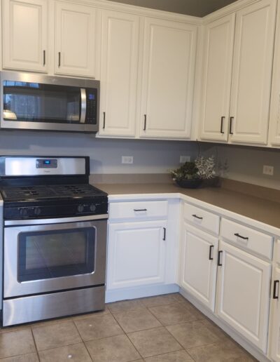 A kitchen with white cabinets and stainless steel appliances.