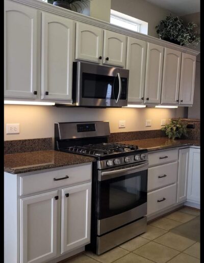 A kitchen with white cabinets and stainless steel appliances.