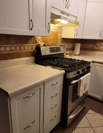 A kitchen with stainless steel appliances and white cabinets.