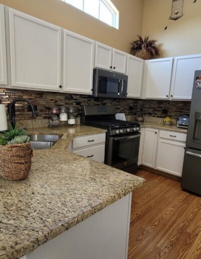 A kitchen with granite counter tops and stainless steel appliances.