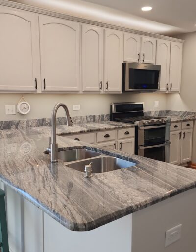 A kitchen with granite counter tops and stainless steel appliances.