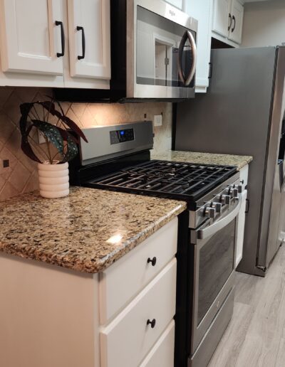 A kitchen with stainless steel appliances and granite counter tops.