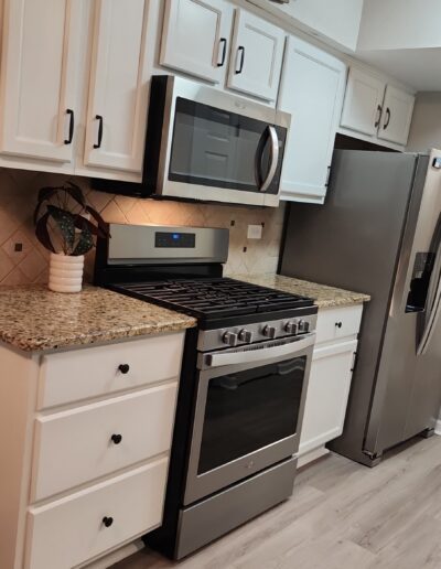 A kitchen with white cabinets and stainless steel appliances.