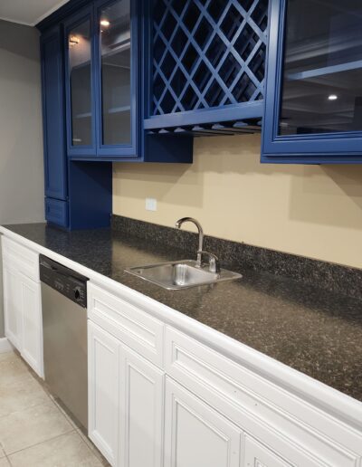 A kitchen with blue cabinets and granite counter tops.