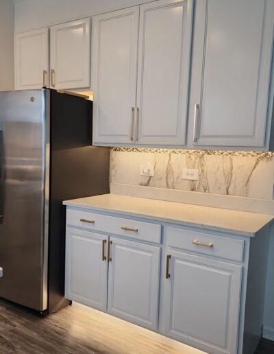 A kitchen with white cabinets and stainless steel appliances.