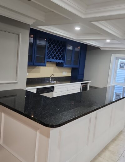 A kitchen with a blue counter top and white cabinets.