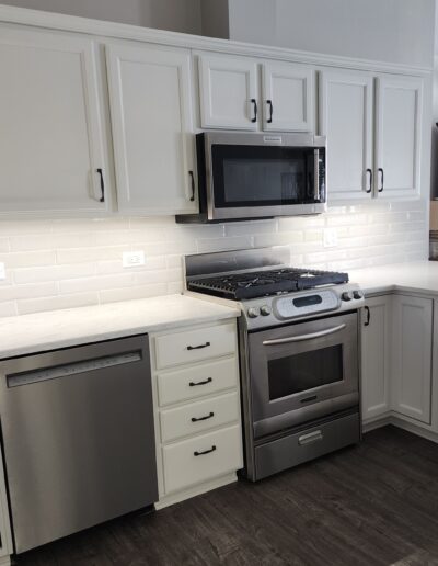 A kitchen with white cabinets and stainless steel appliances.