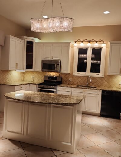 A kitchen with white cabinets and a center island.