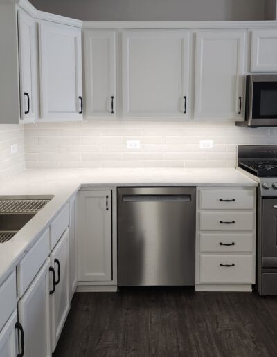 A kitchen with white cabinets and stainless steel appliances.