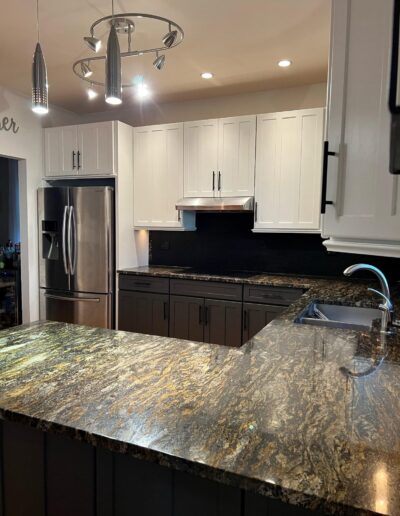 A kitchen with granite counter tops and stainless steel appliances.