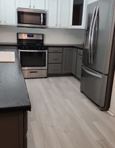 A kitchen with stainless steel appliances and wood floors.