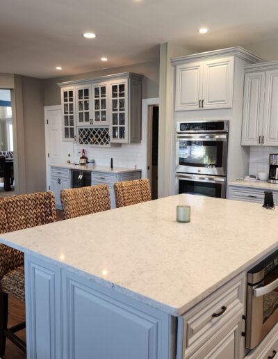 A kitchen with a large island and chairs.