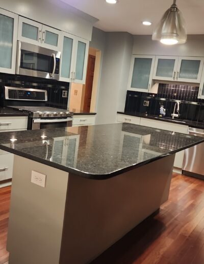 A kitchen with stainless steel appliances and granite counter tops.