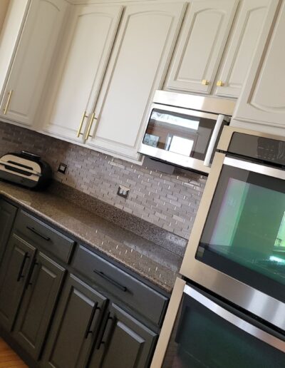 A kitchen with stainless steel appliances and white cabinets.