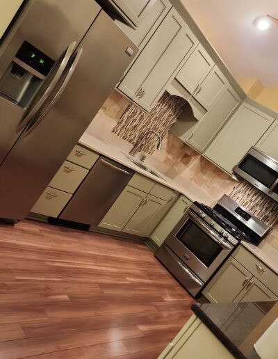 A kitchen with stainless steel appliances and wood floors.