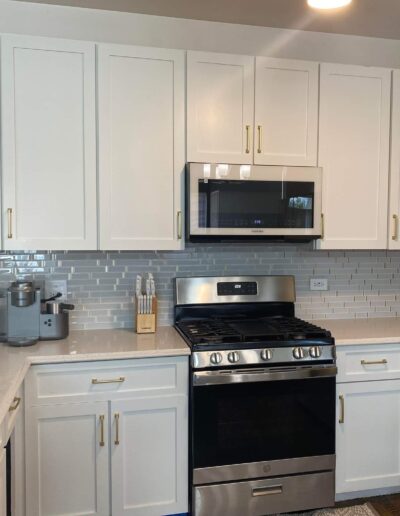 A kitchen with white cabinets and stainless steel appliances.