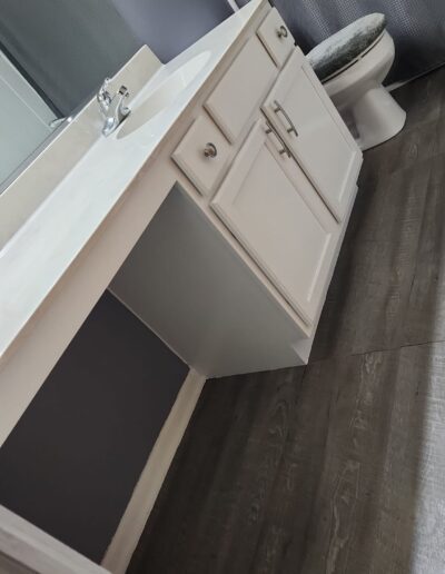 A bathroom with white cabinets and a toilet.