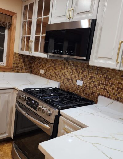 A kitchen with white cabinets and stainless steel appliances.