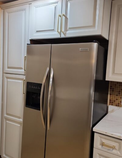 A kitchen with stainless steel appliances and white cabinets.